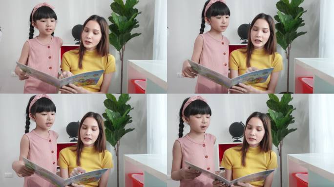 美丽的亚洲老师正在为她可爱的六岁亚洲学生女孩读童话故事，让她在小学听。用爱和关怀教学。他们在课堂上学