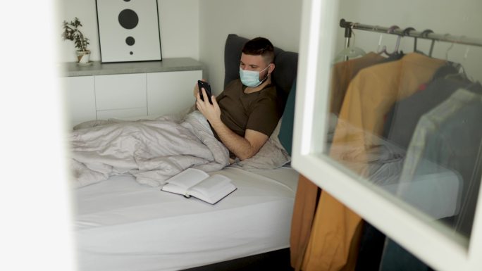 冠状病毒大流行期间，男子在床上视频通话