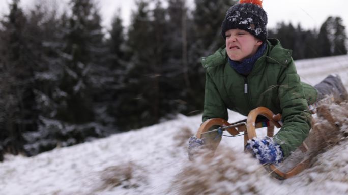 冬天的一天，小男孩在山上滑雪