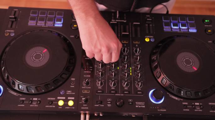 DJ的手放在混音台上的特写