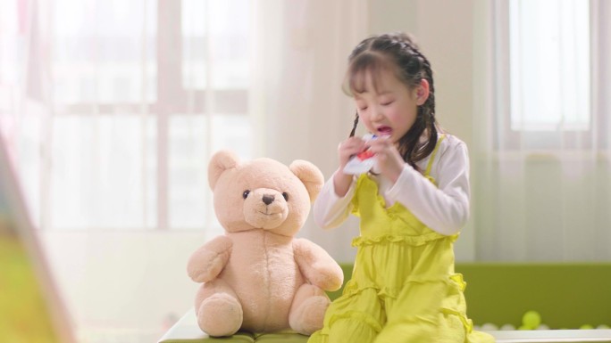小女孩与小熊玩具室内玩耍吃零食
