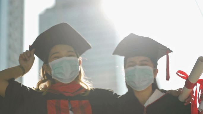微笑的女人戴着防护面具毕业后一起笑