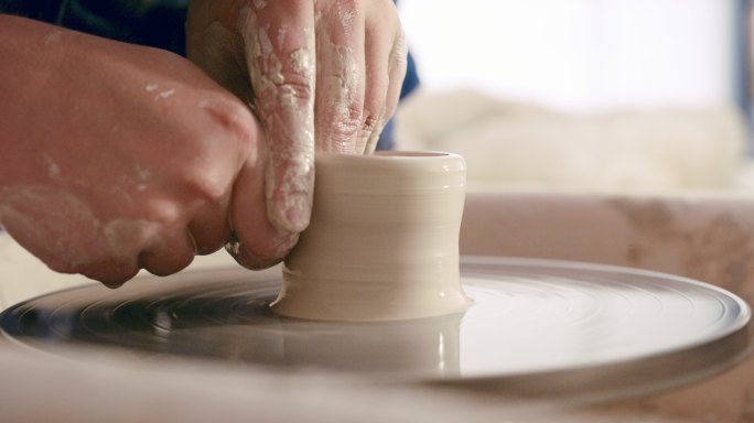 在一个工作室里，陶工手在雕刻一个陶罐，在一个有着复制空间的艺术课上享受一种有趣的爱好。通过不同的纹理