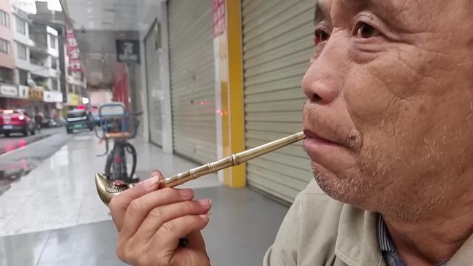 抽烟的男子吸晒烟的烟斗古老的烟斗铜烟枪