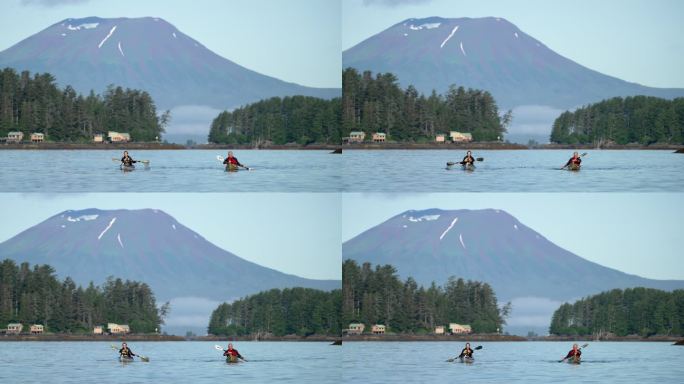 两名老年皮划艇运动员在身后有火山的河流上划水