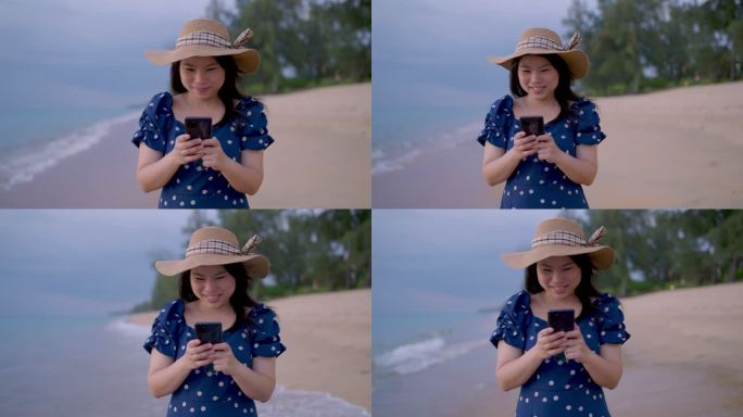 亚洲成年女性在沙滩上散步时，在智能手机上随意地微笑着在社交媒体平台上发布照片和文字，同时在沙滩上漫步