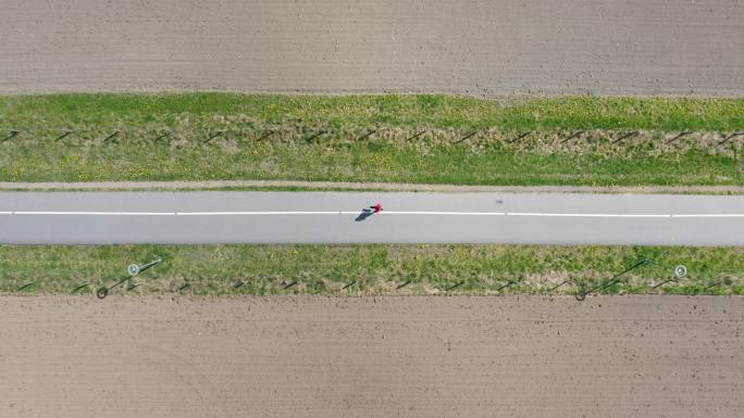 在乡间小路上跑步俯瞰顶视图农村公路一人跑
