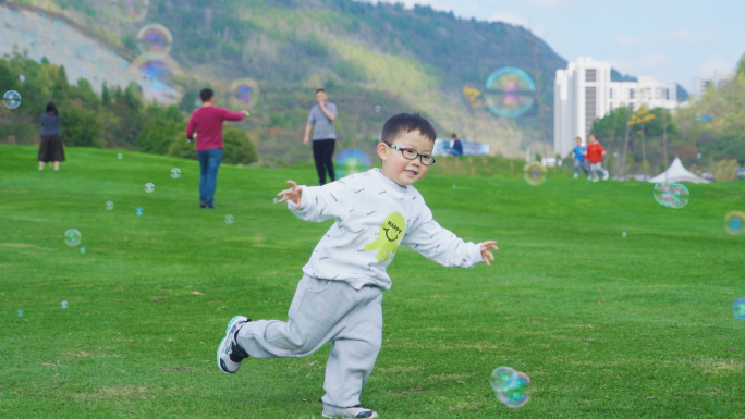 小孩草地玩泡泡追逐打闹快乐奔跑家庭教育