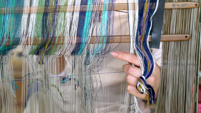 一名纺织工人整理准备编织的棉线的特写