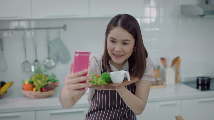 美女直播和自拍三文鱼蔬菜沙拉通过社交媒体，看起来很幸福-生活方式健康饮食，健康生活方式。4K分辨率，