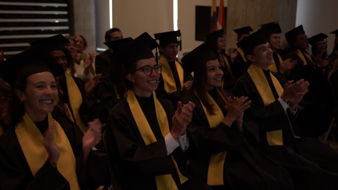 毕业典礼演讲后，快乐的拉丁美洲学生在毕业典礼上鼓掌