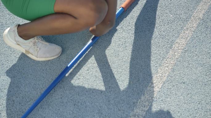 女子田径运动员在蓝色跑道上标枪伸展