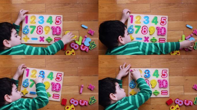 小男孩在地板上玩数字板。
