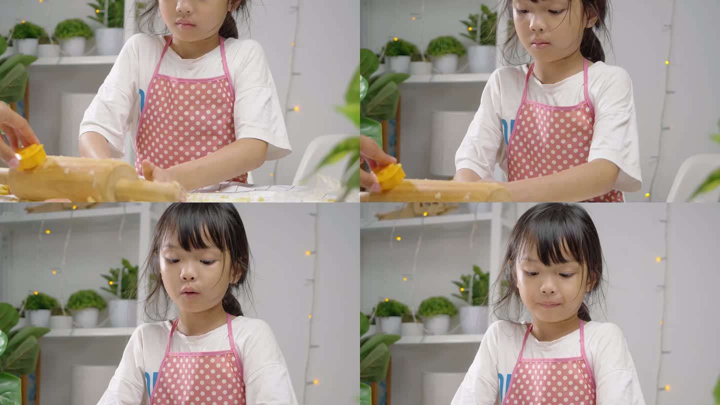 亚洲女孩用饼干切割机制作自制饼干庆祝圣诞节，生活方式理念。