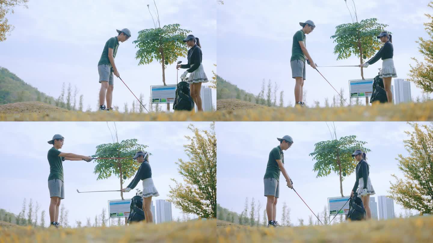 亚洲年轻的高尔夫球手，在高尔夫球场上教弟弟打高尔夫。