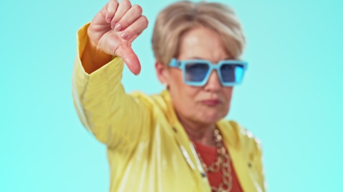 一位年长女性在蓝色背景下竖起大拇指的照片