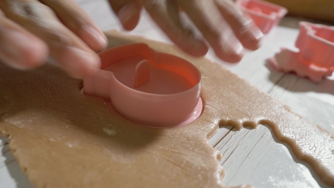 儿童的手使用饼干切割机制作自制饼干，以庆祝圣诞节，生活方式理念。