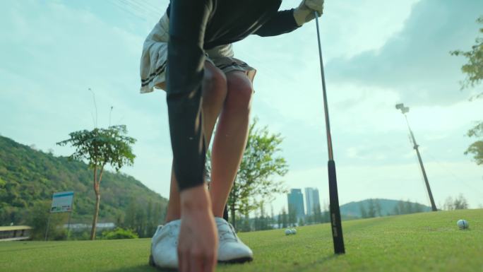 亚洲年轻的高尔夫球手，在高尔夫球场上教弟弟打高尔夫。