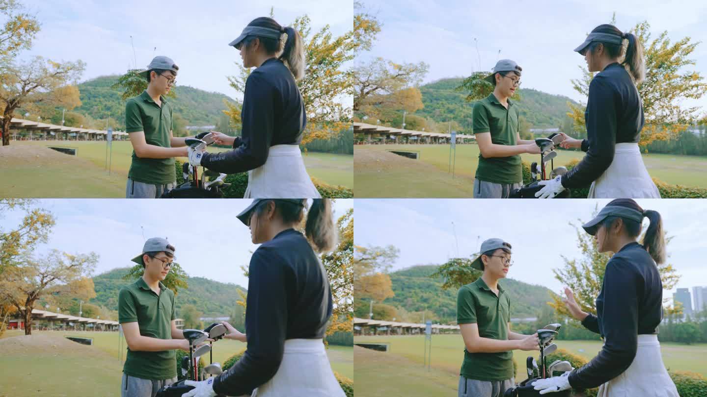 亚洲年轻女子高尔夫球手在高尔夫练习场教年轻人打高尔夫