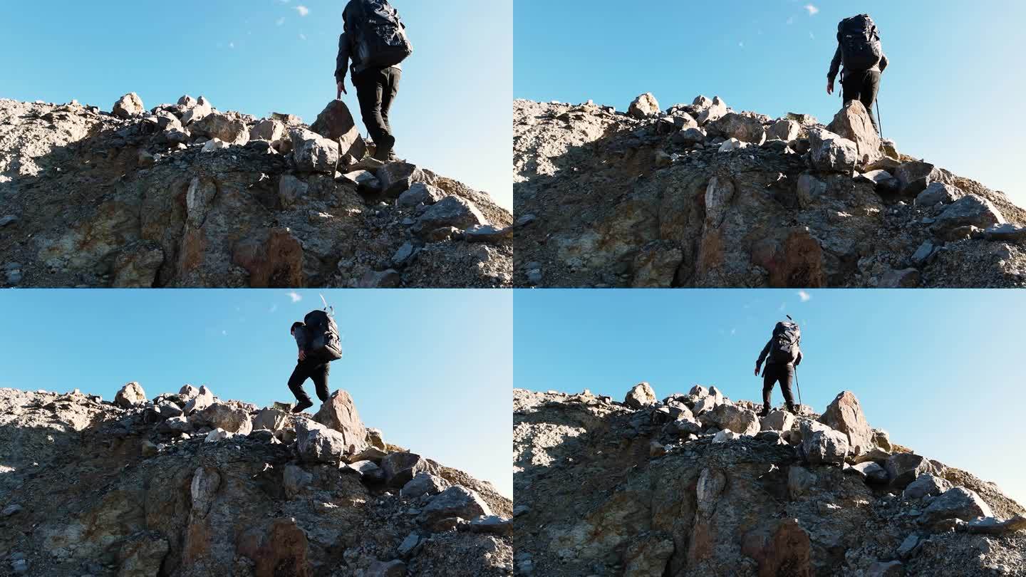 男人背着登山包爬山背影登上山顶攀登顶峰