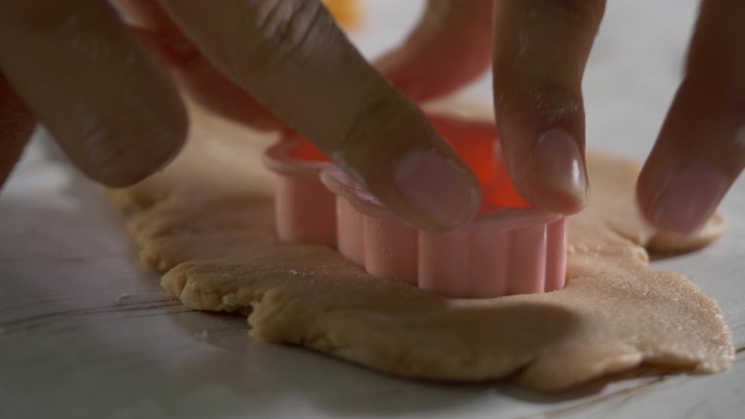 儿童的手使用饼干切割机制作自制饼干，以庆祝圣诞节，生活方式理念。
