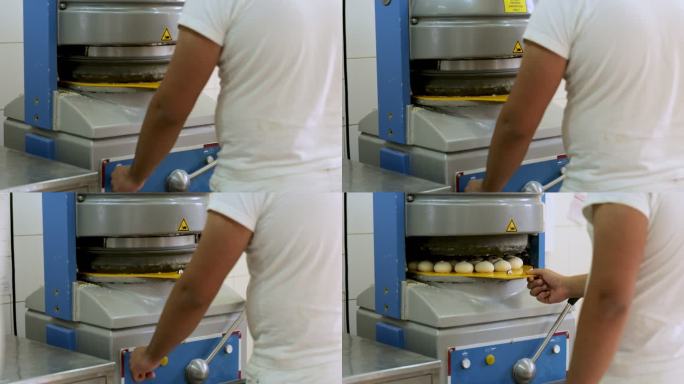 面包师，将盛有面团的托盘放入机器，由机器制作出完美的圆形面包