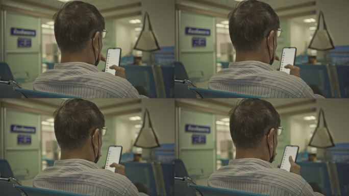 老年男子在医院看智能手机