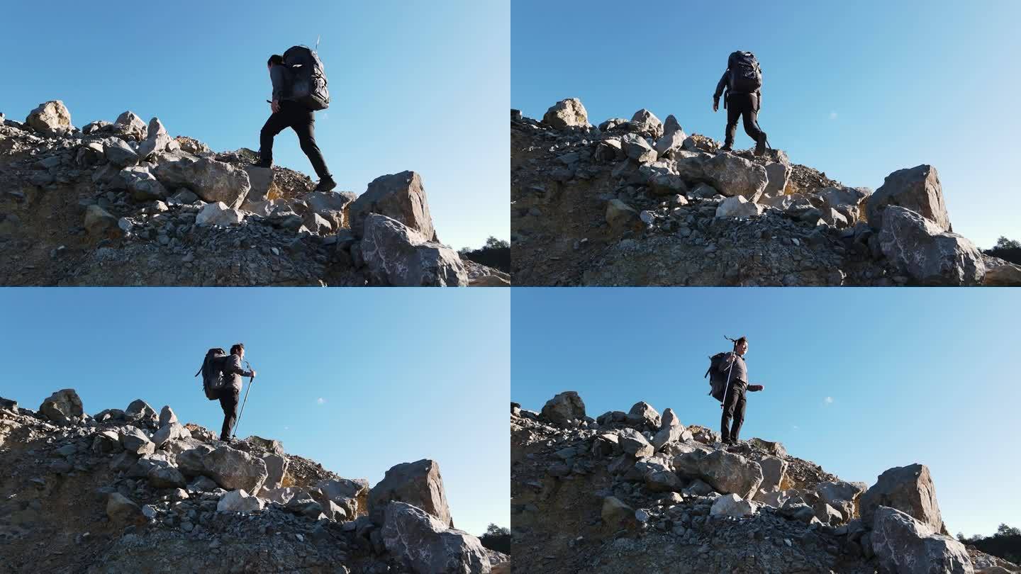 男人背着登山包爬山背影登上山顶攀登顶峰