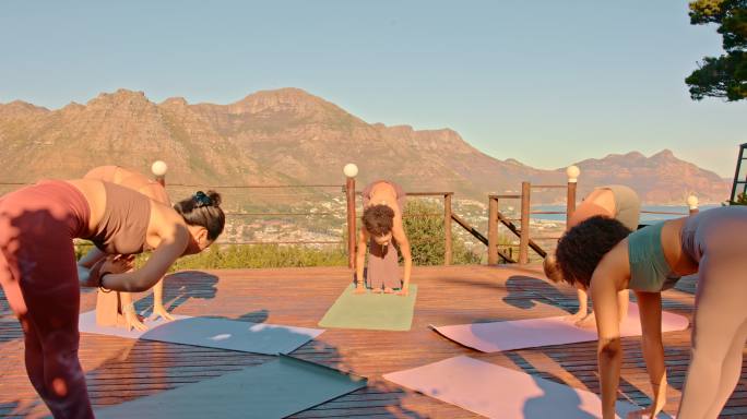 在大自然的户外练习中，多样化的瑜伽女性做namaste体式。一群活跃的朋友在静修时使用垫子并进行整体