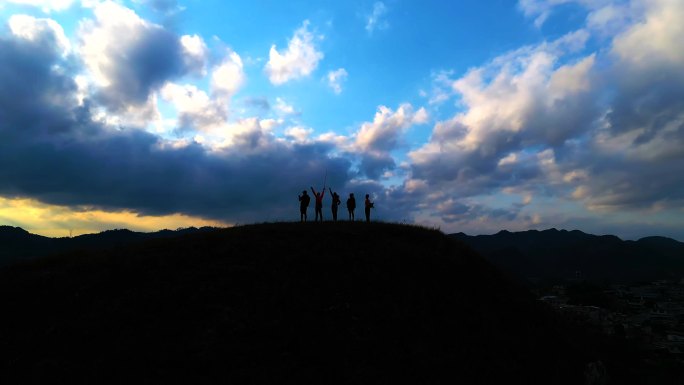 一群背包客站在山顶俯瞰风景登山到达山顶