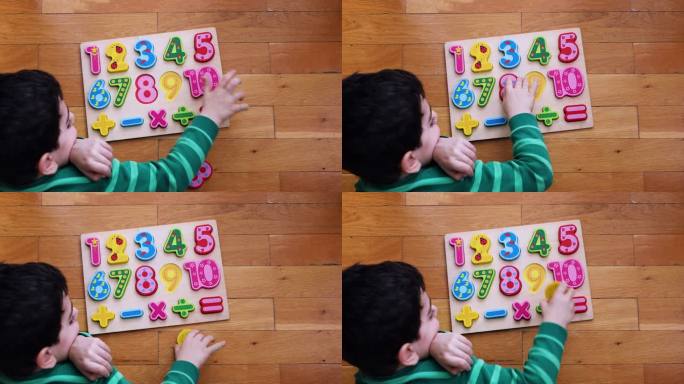 小男孩在地板上玩数字板。
