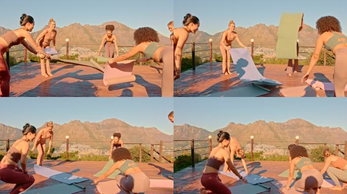 一群不同的女性正准备在屋顶上做瑜伽。一组女性瑜伽练习者使用垫子开始冥想，以提高身体、心灵和精神的健康
