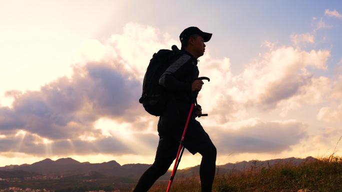 意境男人黄昏登山在山顶徒步旅行意境逆光走