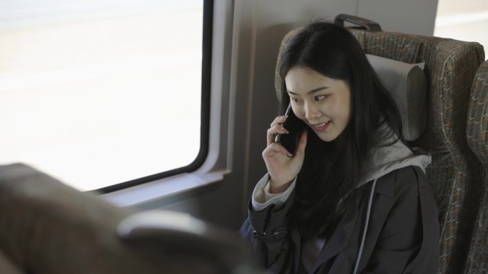 亚洲女孩在高铁上看智能手表