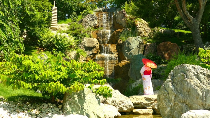 穿着和服的女人欣赏公园里的瀑布