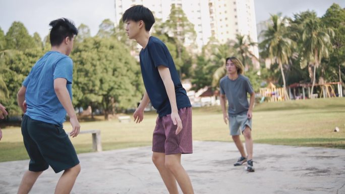 慢动作Z世代亚洲中国青少年男孩挑战球员，并在周末早晨与朋友练习篮球比赛时投篮