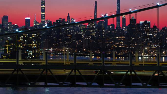 曼哈顿中城在夜晚照亮了天际线。RFK大桥上的交通景观。无人机镜头与平移相机运动。