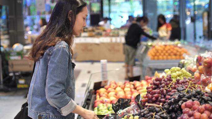亚洲年轻女子在超市买新鲜蔬菜