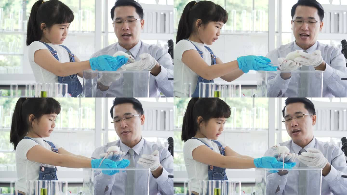 正面图：泰国老师教泰国女孩如何抱实验鼠