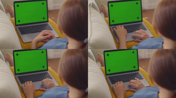 亚洲孕妇在家工作时使用绿色屏幕上的笔记本电脑