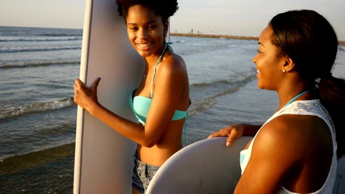 两位非洲裔美国女性朋友准备去冲浪