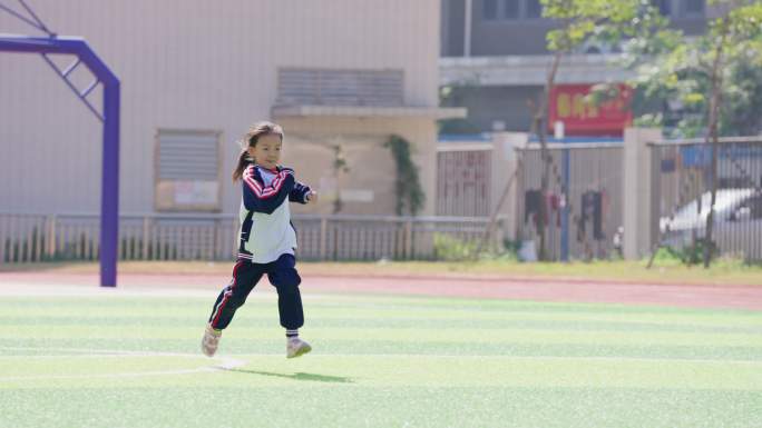 小学生运动成长奔跑在足球场上