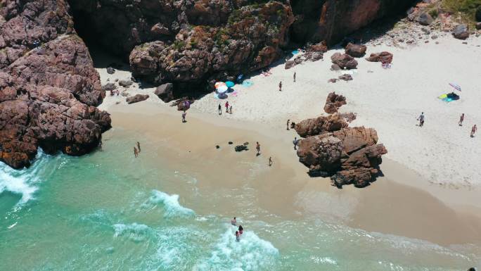 4k空中无人机拍摄的一群人在海滩度假和享受的画面