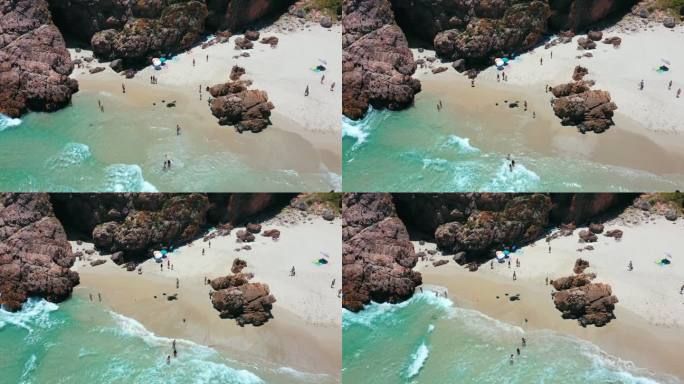 4k空中无人机拍摄的一群人在海滩度假和享受的画面