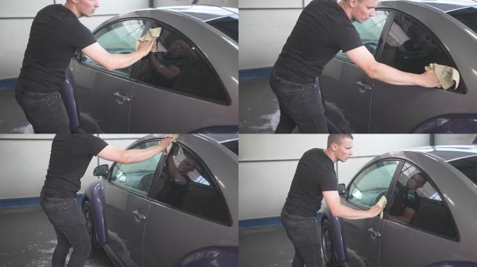 专注年轻男性洗车后用拖把擦干车窗