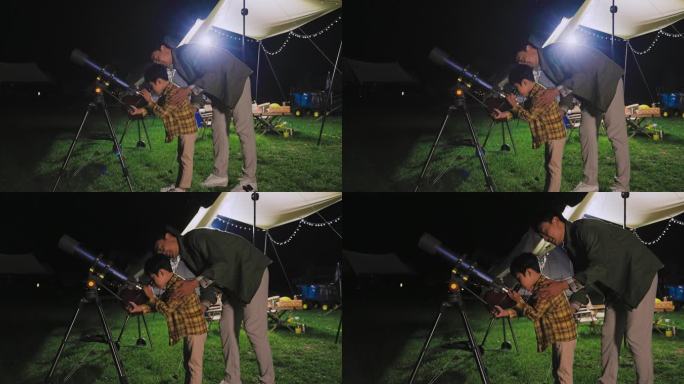 傍晚爸爸和儿子在露营地用望远镜看星空