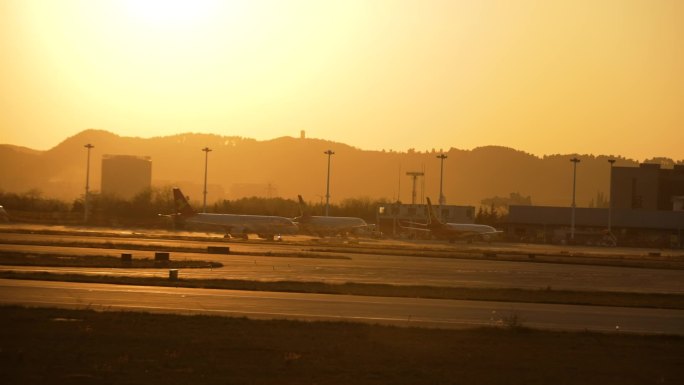 黄昏日落在跑道上滑行的飞机逆光飞翔日出飞