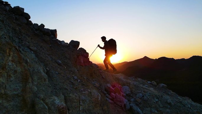 男人逆光登山剪影攀登顶峰迎难而上爬山背影