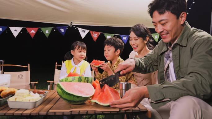 傍晚一家人在露营地吃西瓜