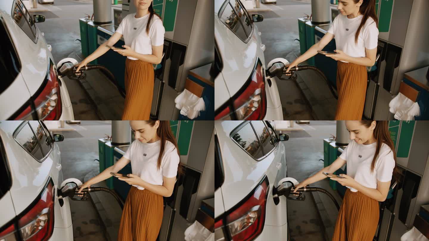 SLO MO年轻女子在给车加油时使用智能手机